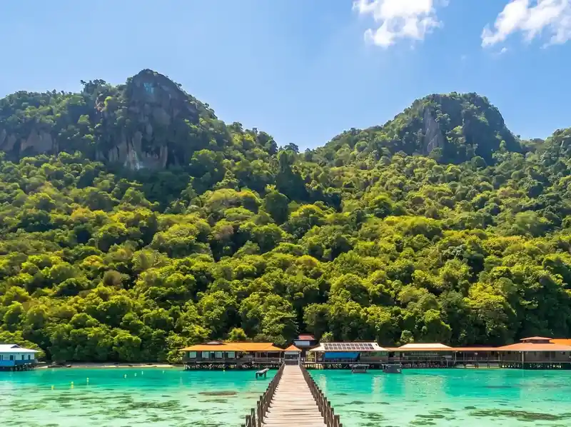 Hiking the Bohey Dulang peak with Amina Holidays in the Tun Sakaran Marine Park for a panoramic view of the turquoise sea.